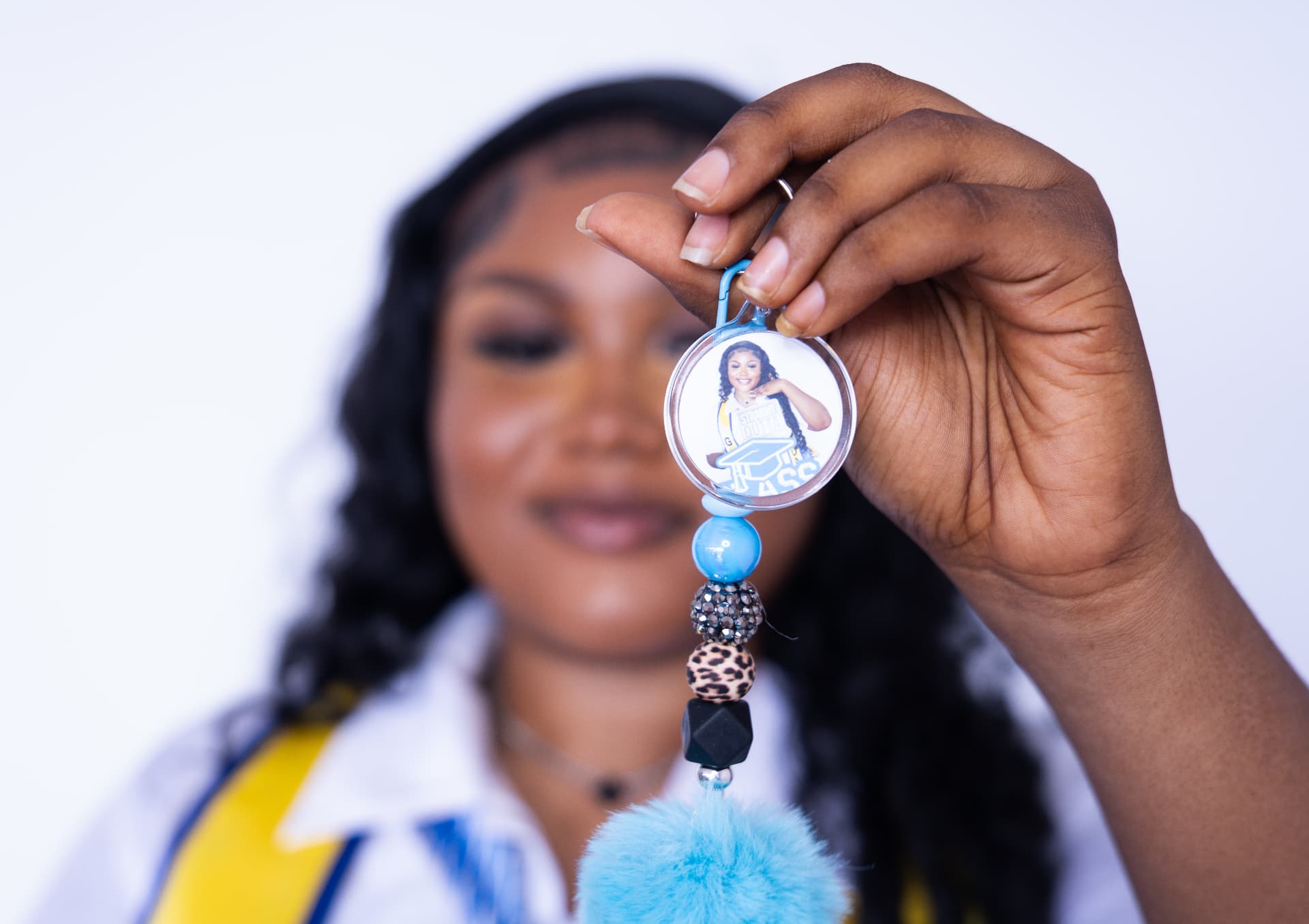 Personalized beaded photo keychain keepsake held at a celebration